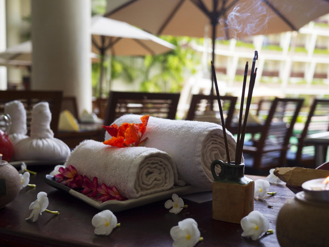 Rolled towels with incense and flowers, an illustrative image for a women's bodywork session.