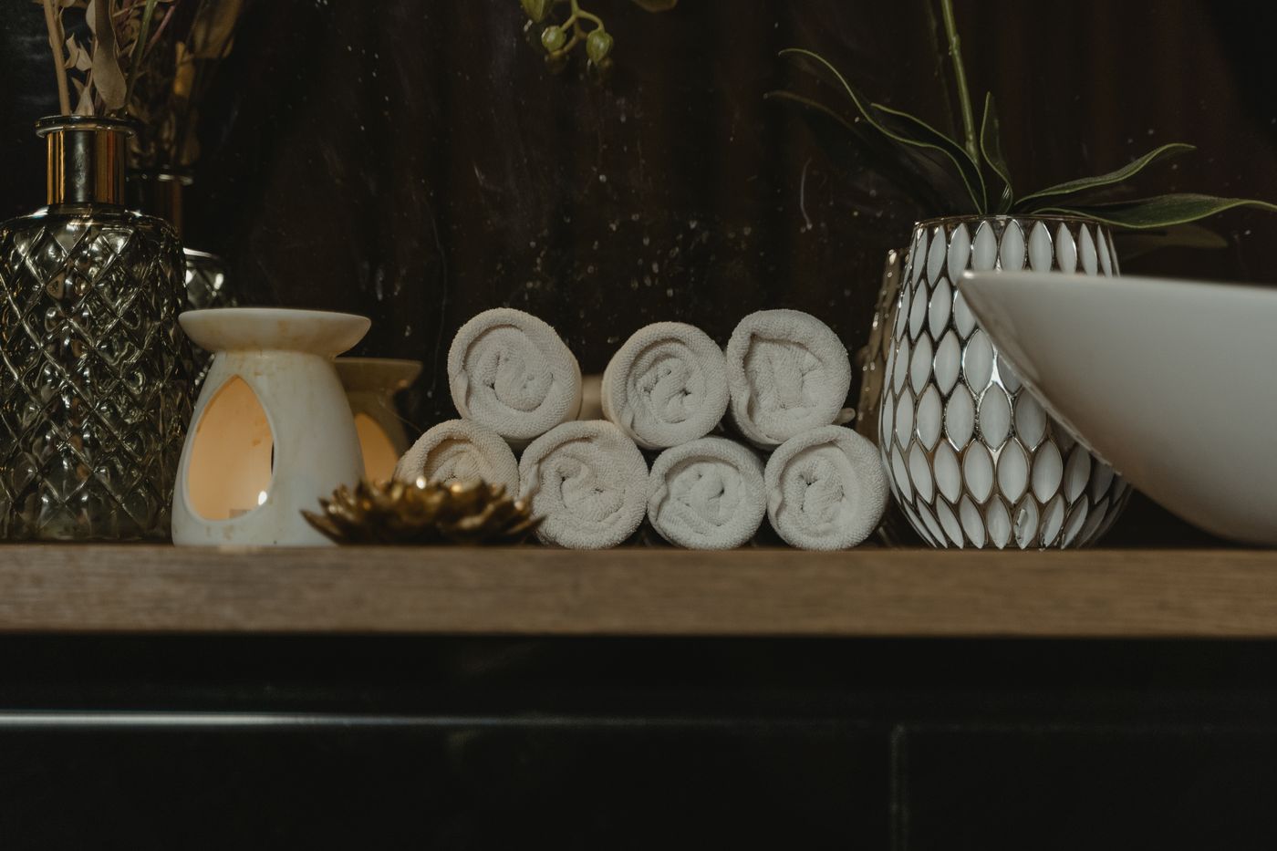 Rolled towels on a wooden table, an illustrative image for a two-practitioner session.
